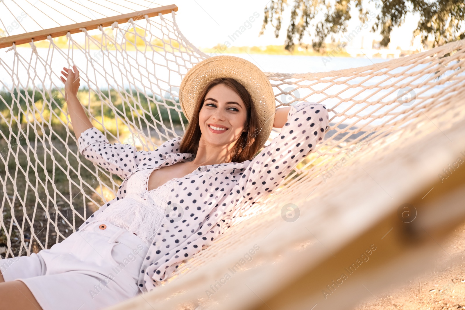 Photo of Young woman relaxing in hammock on beach. Summer vacation
