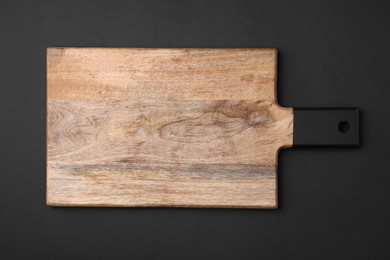 One wooden board on black background, top view