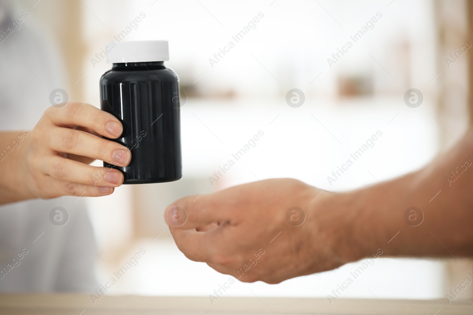 Photo of Pharmacist giving medicine to customer in drugstore, closeup