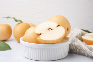 Bowl with delicious apple pears on white table