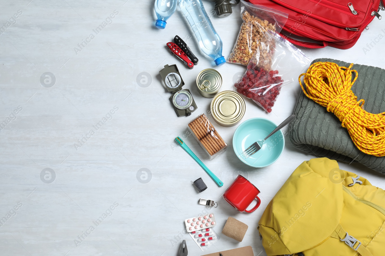 Photo of Earthquake supply kit on white wooden table, flat lay. Space for text