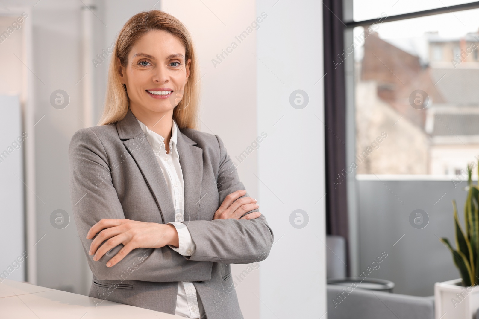 Photo of Happy real estate agent indoors. Space for text