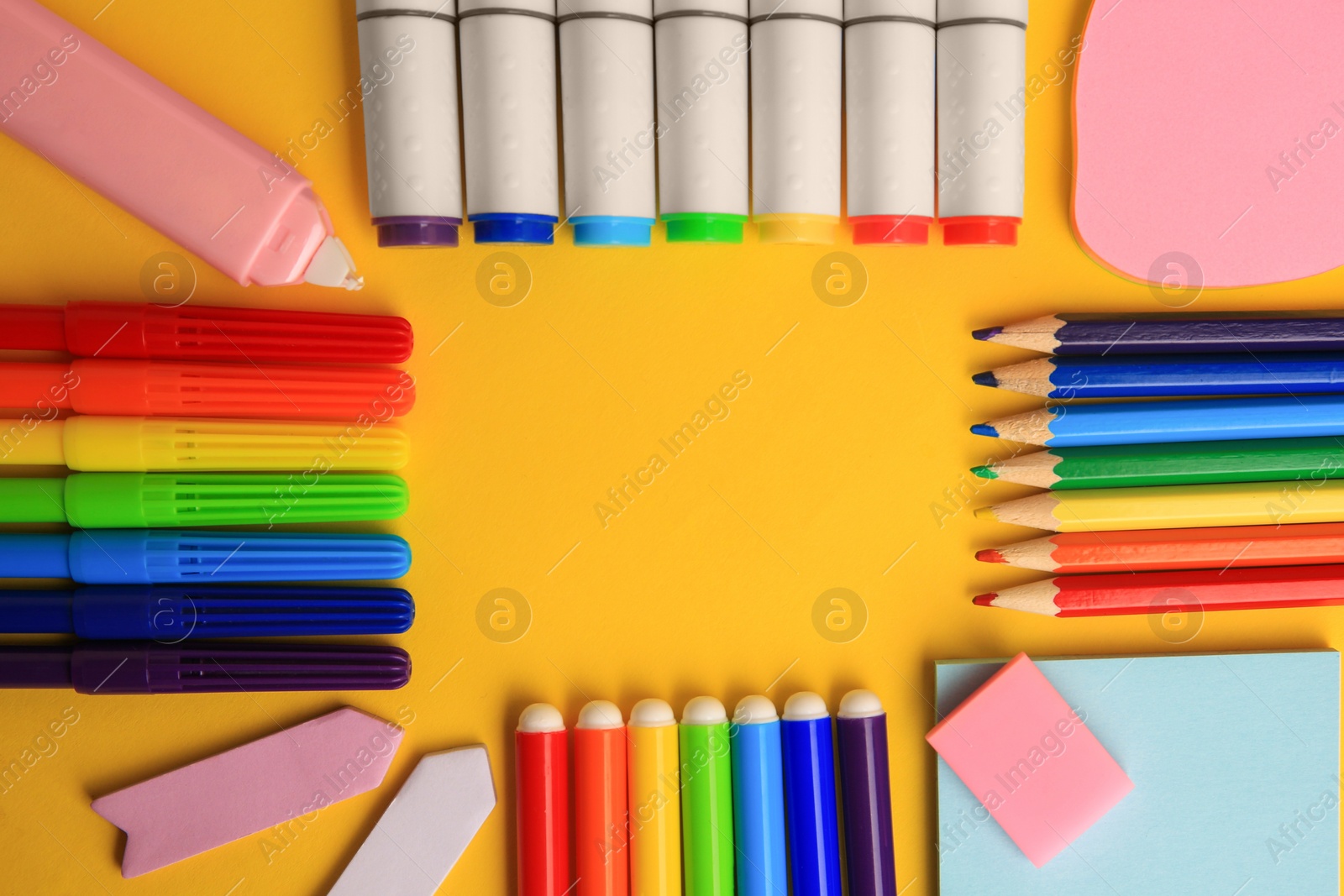 Photo of Frame of different school stationery on yellow background, flat lay with space for text. Back to school