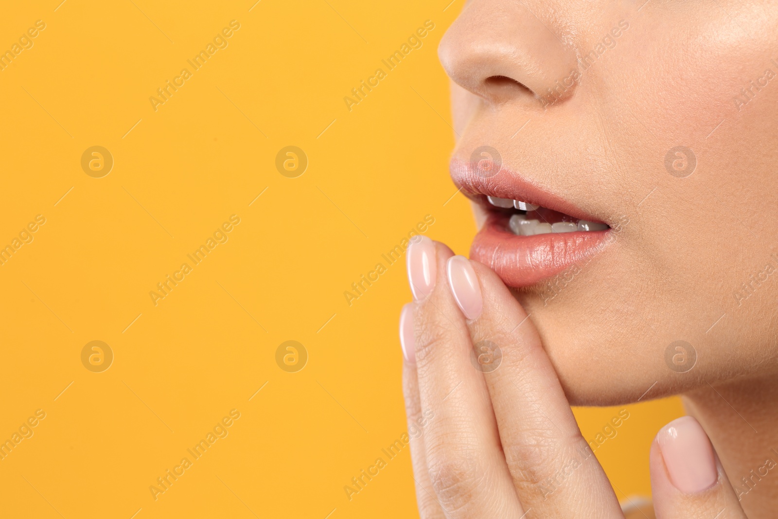 Photo of Young woman wearing nude lipstick on color background, closeup. Space for text