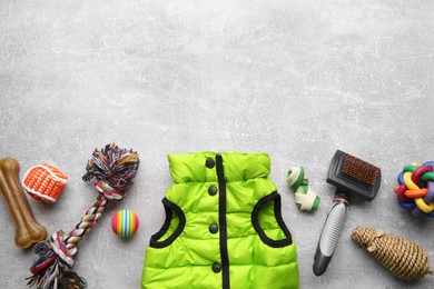 Photo of Flat lay composition with dog clothes, food and accessories on grey table. Space for text