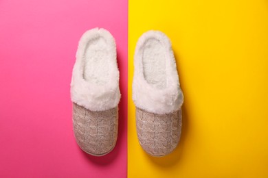 Photo of Pair of beautiful soft slippers on colorful background, top view