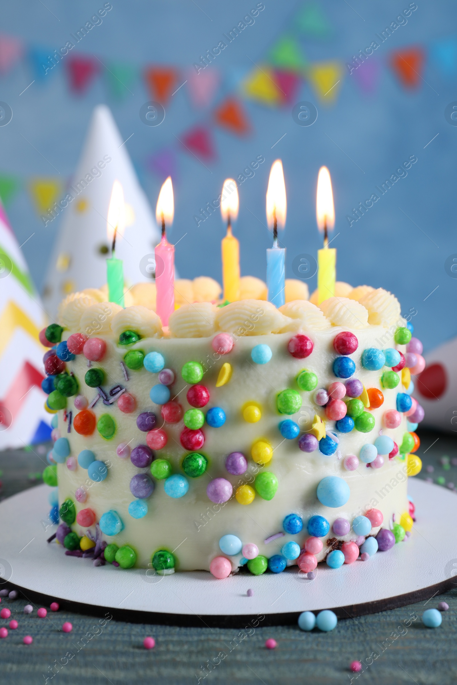 Photo of Cute bento cake with tasty cream and burning candles on light blue wooden table