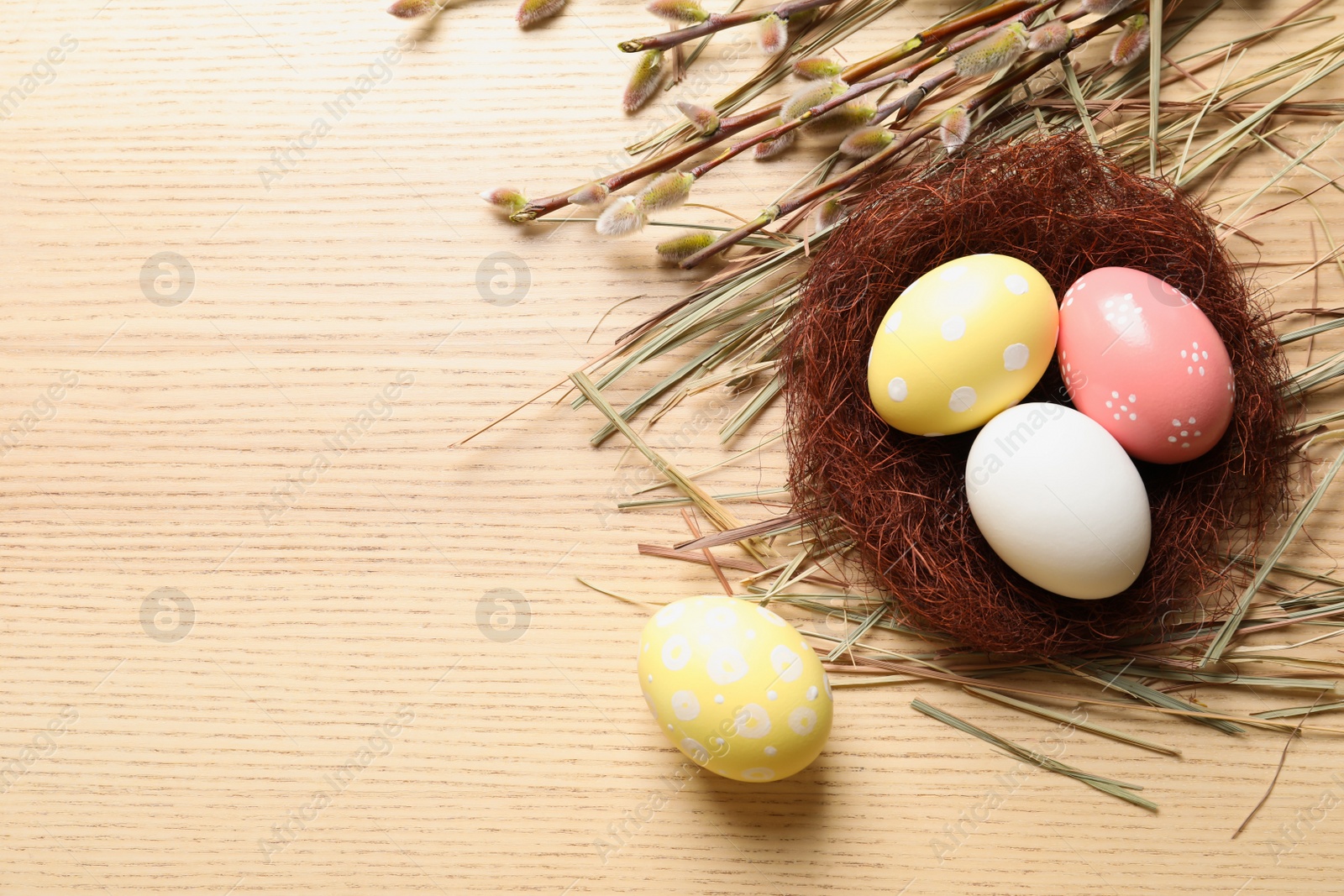 Photo of Flat lay composition with painted Easter eggs on wooden table, space for text