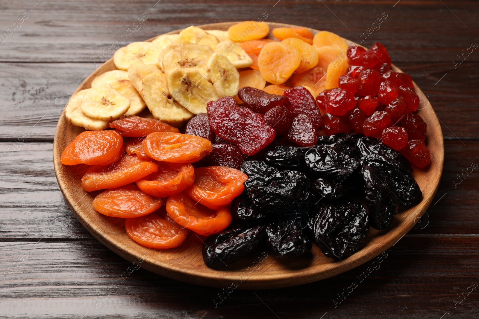 Photo of Delicious dried fruits on wooden table, closeup