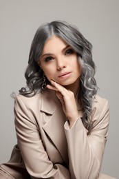 Image of Portrait of beautiful woman with ash hair color on grey background