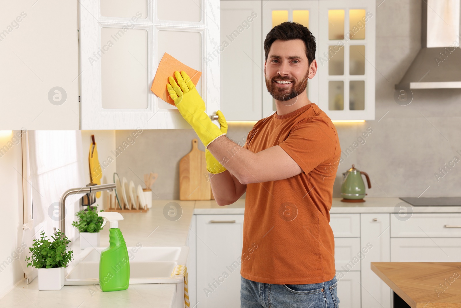 Photo of Spring cleaning. Man tidying up kitchen at home