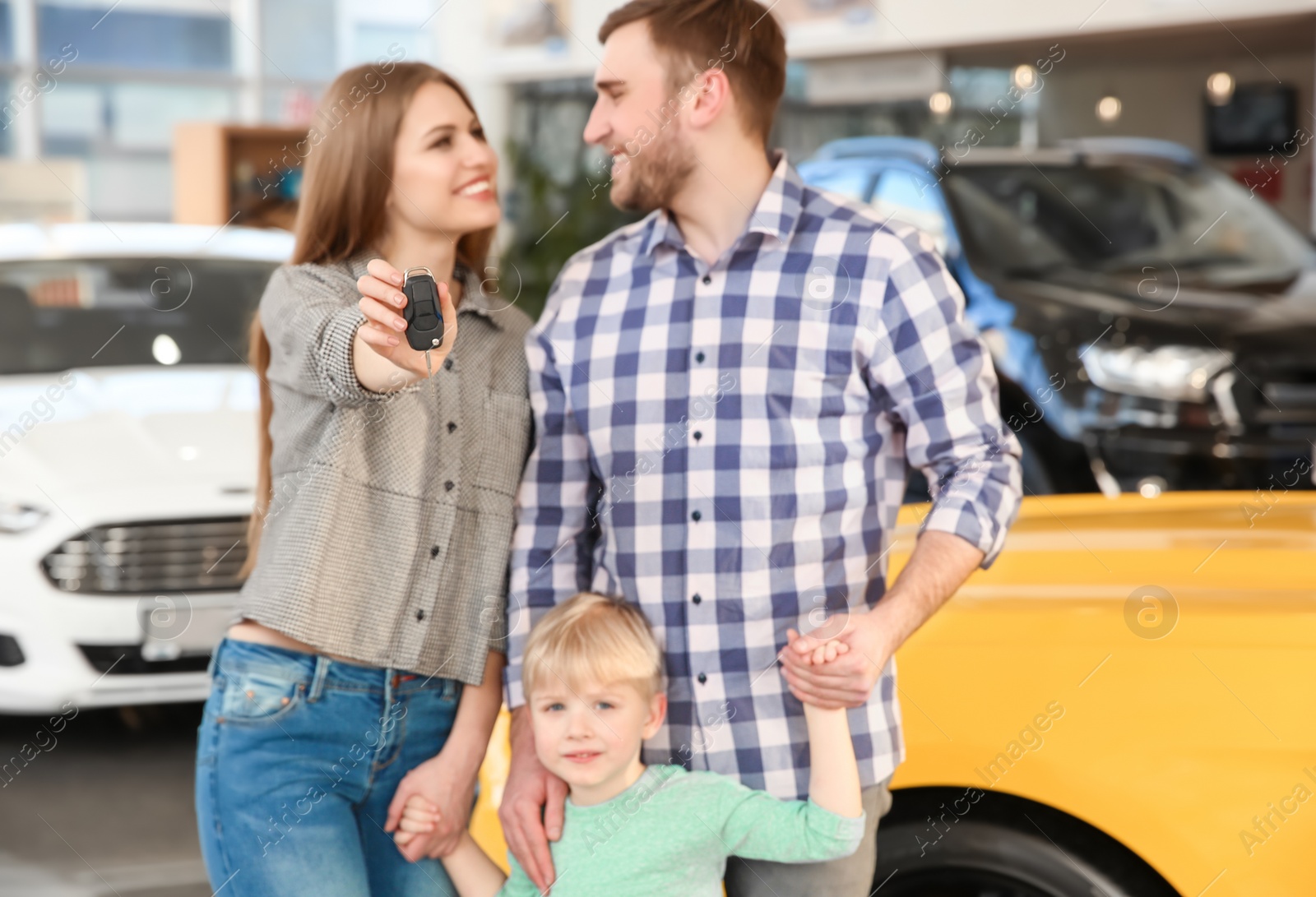 Photo of Young family holding car key in salon