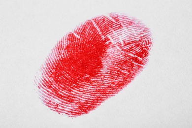 Photo of Red fingerprint on white background. Friction ridge pattern