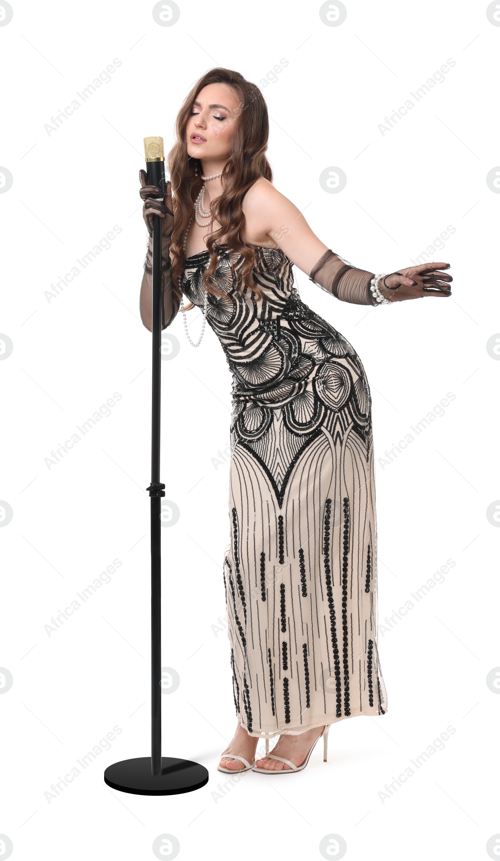 Photo of Beautiful young woman in stylish dress with microphone singing on white background