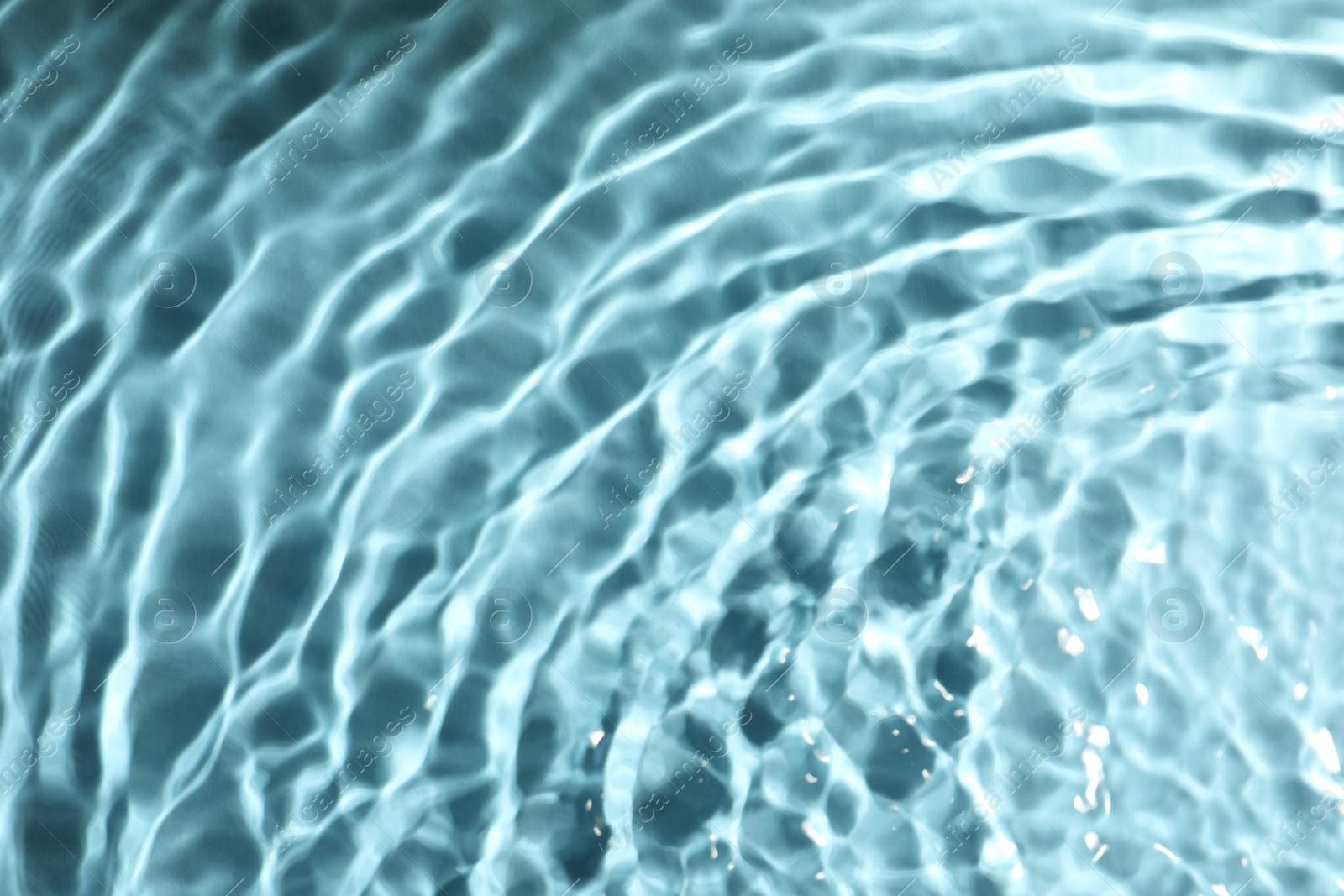 Photo of Closeup view of water with rippled surface on turquoise background