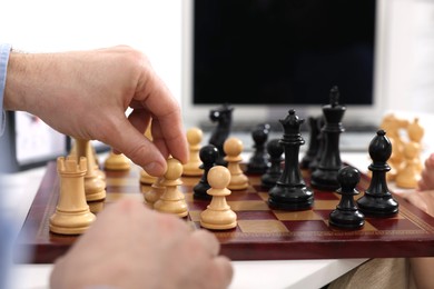 Man playing chess at table indoors, closeup