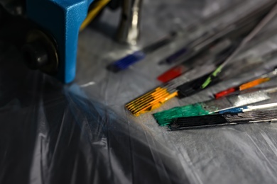 Tattoo needles covered with colorful inks on table, closeup