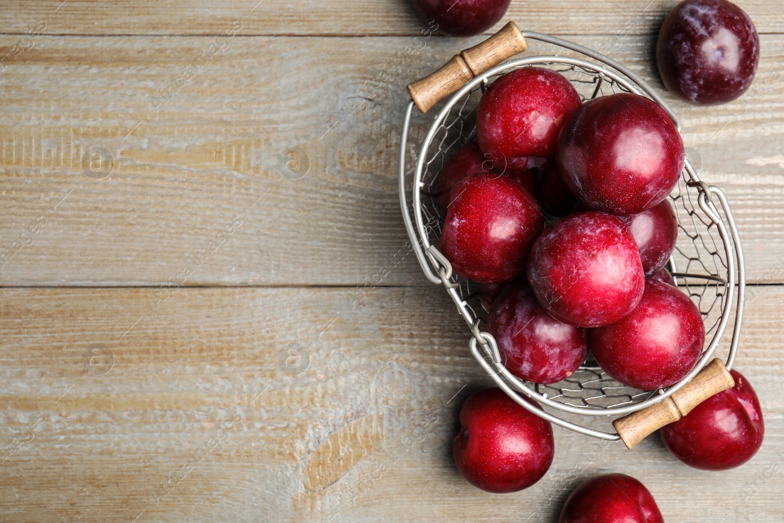 Photo of Delicious ripe plums on wooden table, flat lay. Space for text