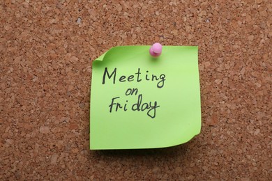 Photo of Paper note with words Meeting on Friday pinned to cork board