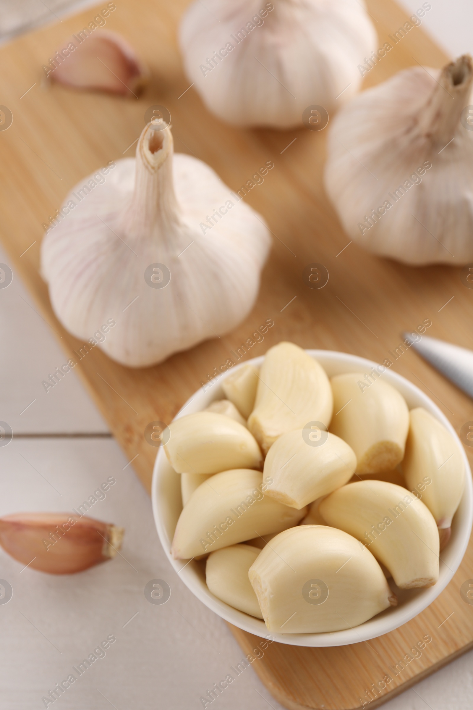 Photo of Fresh garlic on white wooden table, closeup. Above view