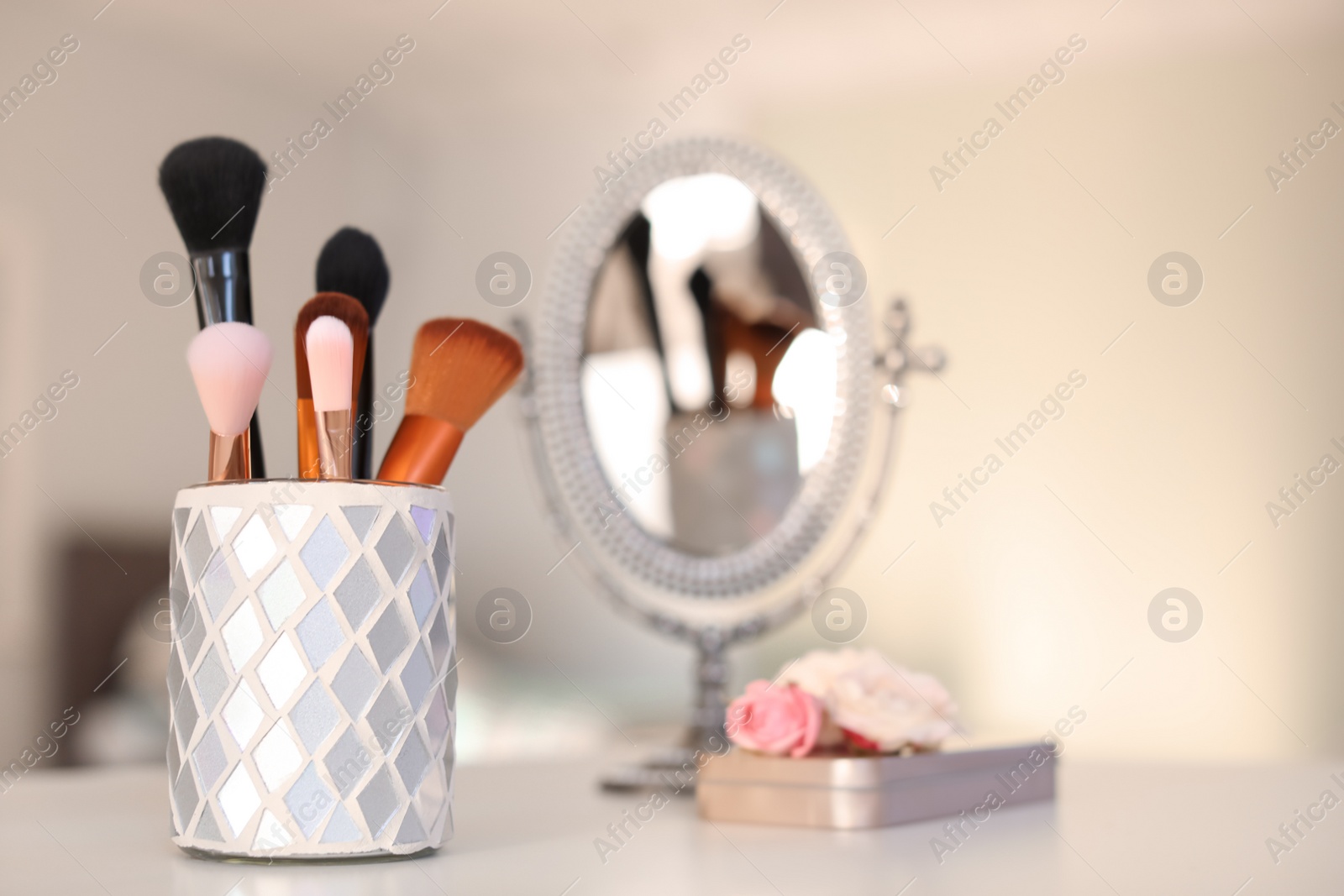 Photo of Holder with makeup brushes on table