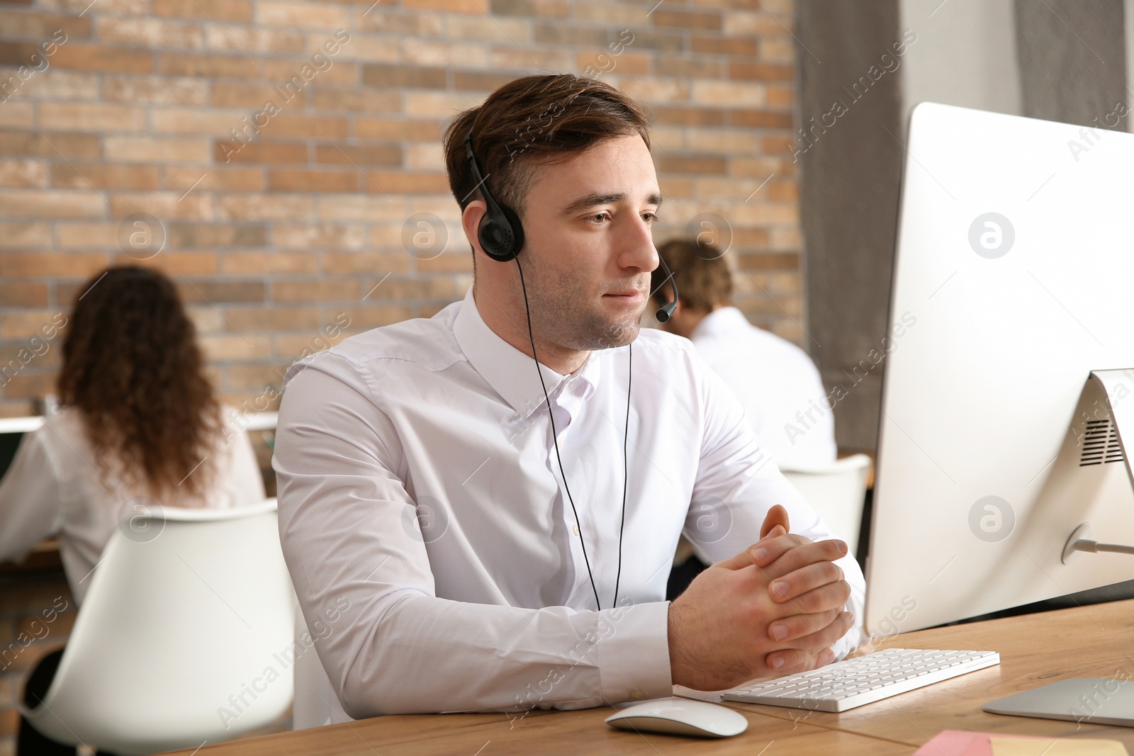 Photo of Technical support operator with headset at workplace