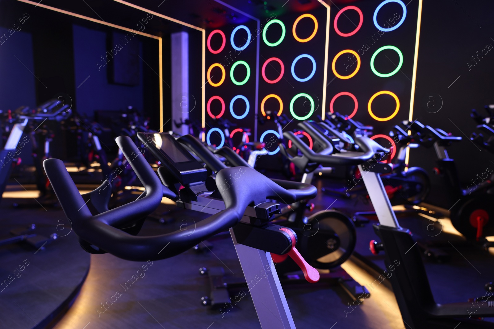 Photo of Many exercise bikes in fitness club. Indoor cycling class