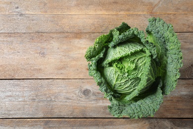 Fresh ripe savoy cabbage on wooden table, top view. Space for text