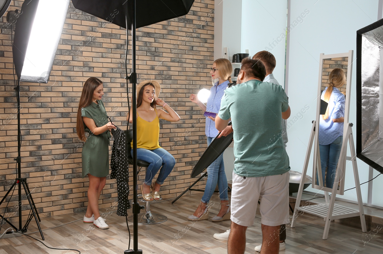 Photo of Professional team working with model in photo studio