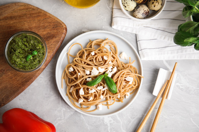 Photo of Tasty buckwheat noodles served on light grey table, flat lay
