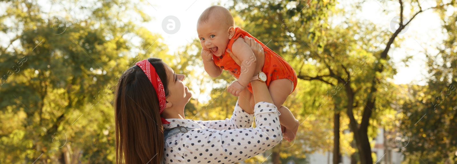 Image of Happy mother with adorable baby in park on sunny day. Banner design 