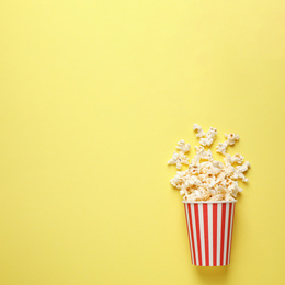 Photo of Delicious popcorn on yellow background, top view. Space for text