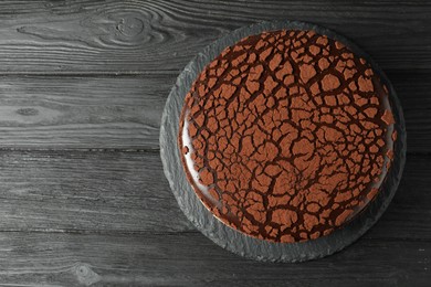 Photo of Delicious chocolate truffle cake on black wooden table, top view. Space for text