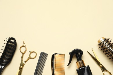 Photo of Different hairdresser tools on beige background, flat lay. Space for text