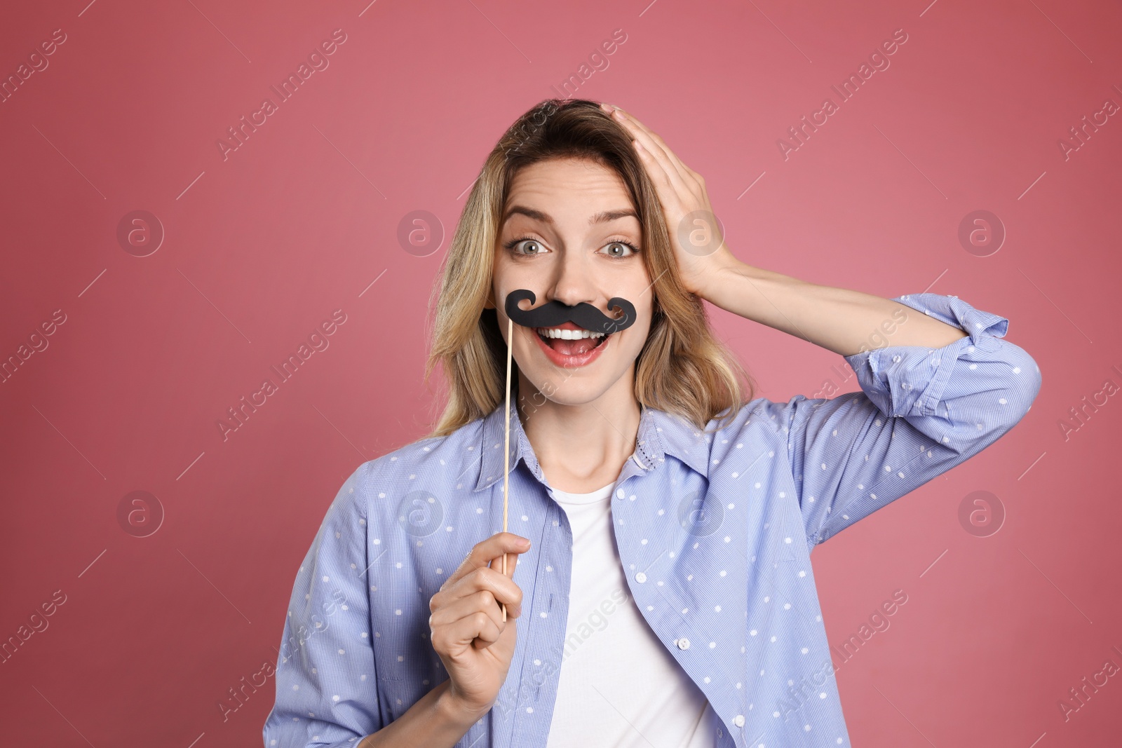 Photo of Funny woman with fake mustache on dusty rose background