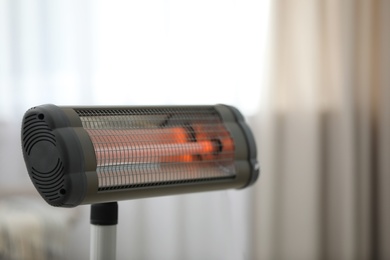 Photo of Modern electric infrared heater at home, closeup