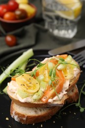 Tasty vegan sandwich with tomatoes, celery and microgreens on plate, closeup