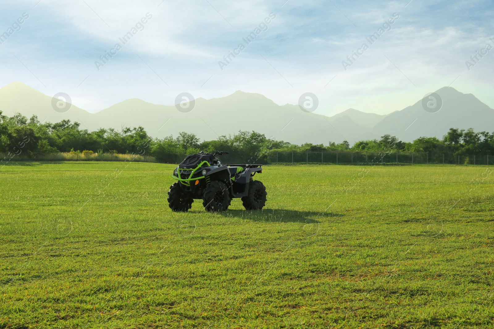 Photo of Modern quad bike in field on sunny day, space for text