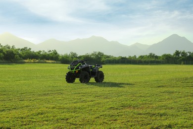 Modern quad bike in field on sunny day, space for text