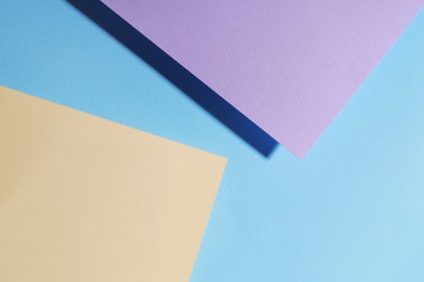 Different colorful paper sheets on light blue background, top view
