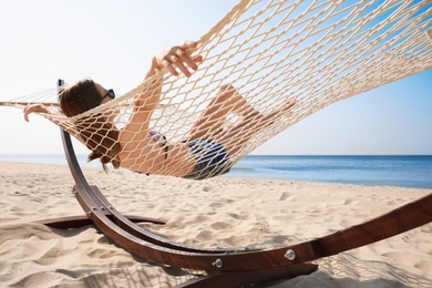 Photo of Young woman relaxing in hammock on beach