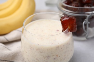 Photo of Glass of delicious date smoothie on table, closeup