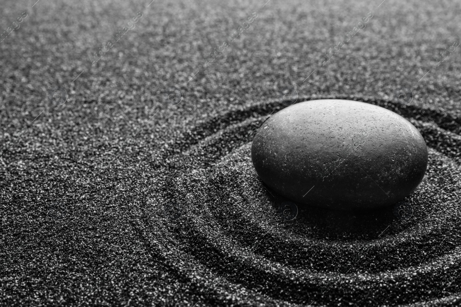 Photo of Black sand with stone and beautiful pattern. Zen concept