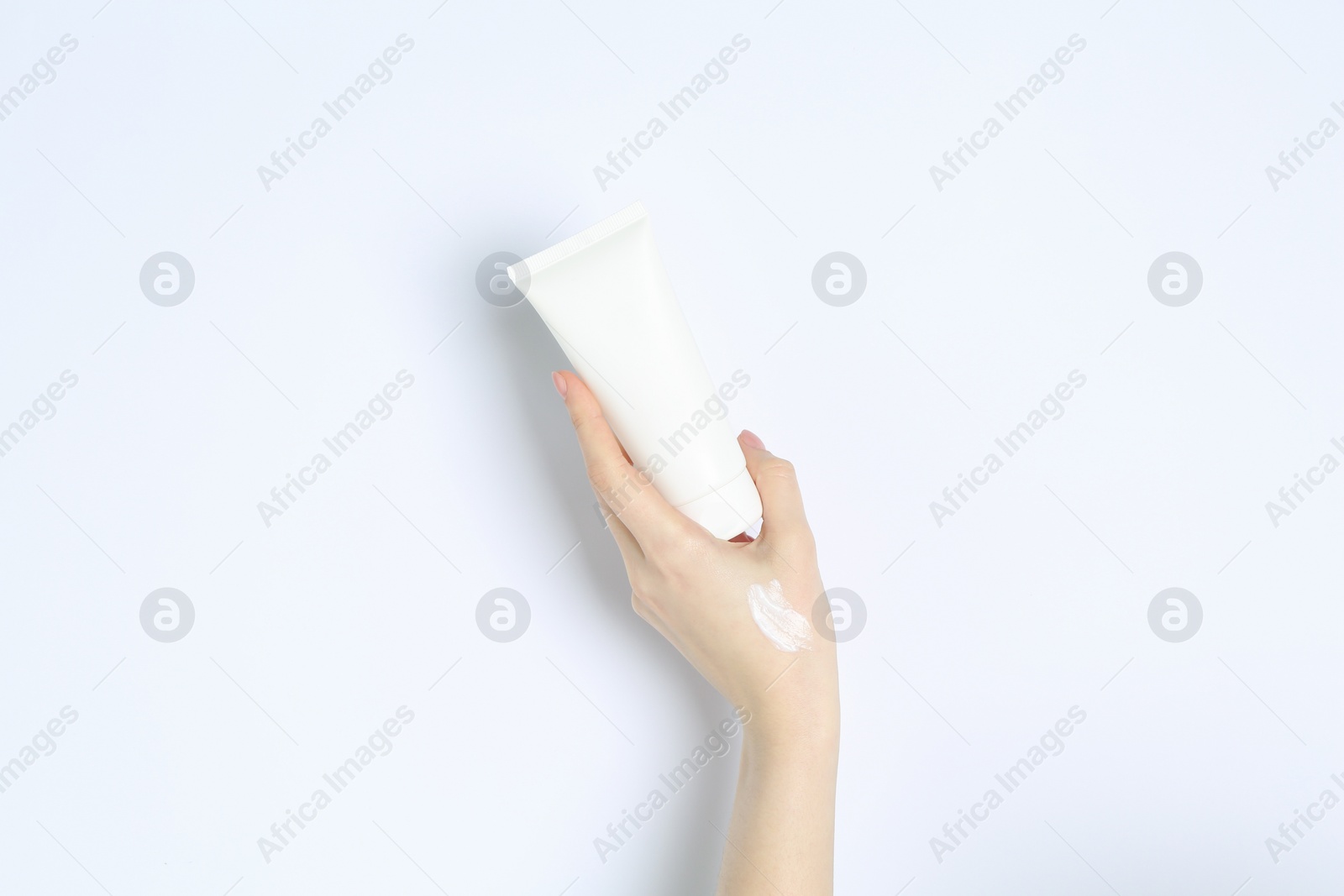 Photo of Woman with tube of cream on white background, closeup