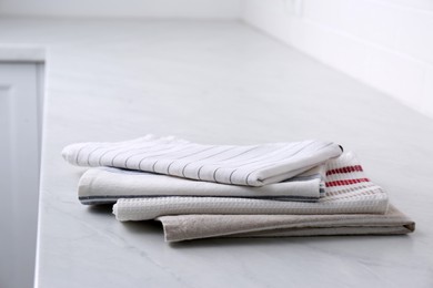 Photo of Stack of soft kitchen towels on countertop indoors