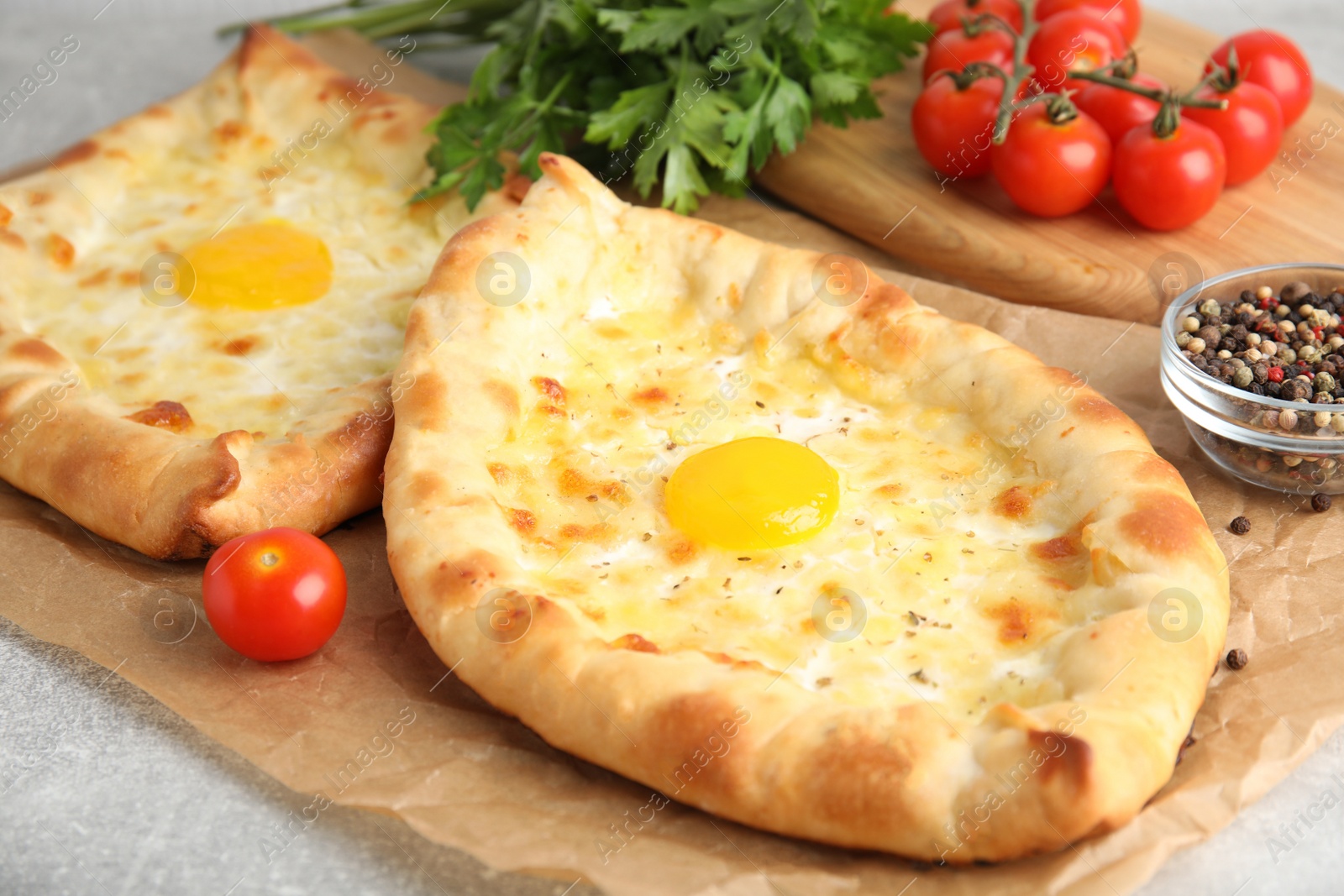 Photo of Fresh delicious Adjarian khachapuris served on grey table