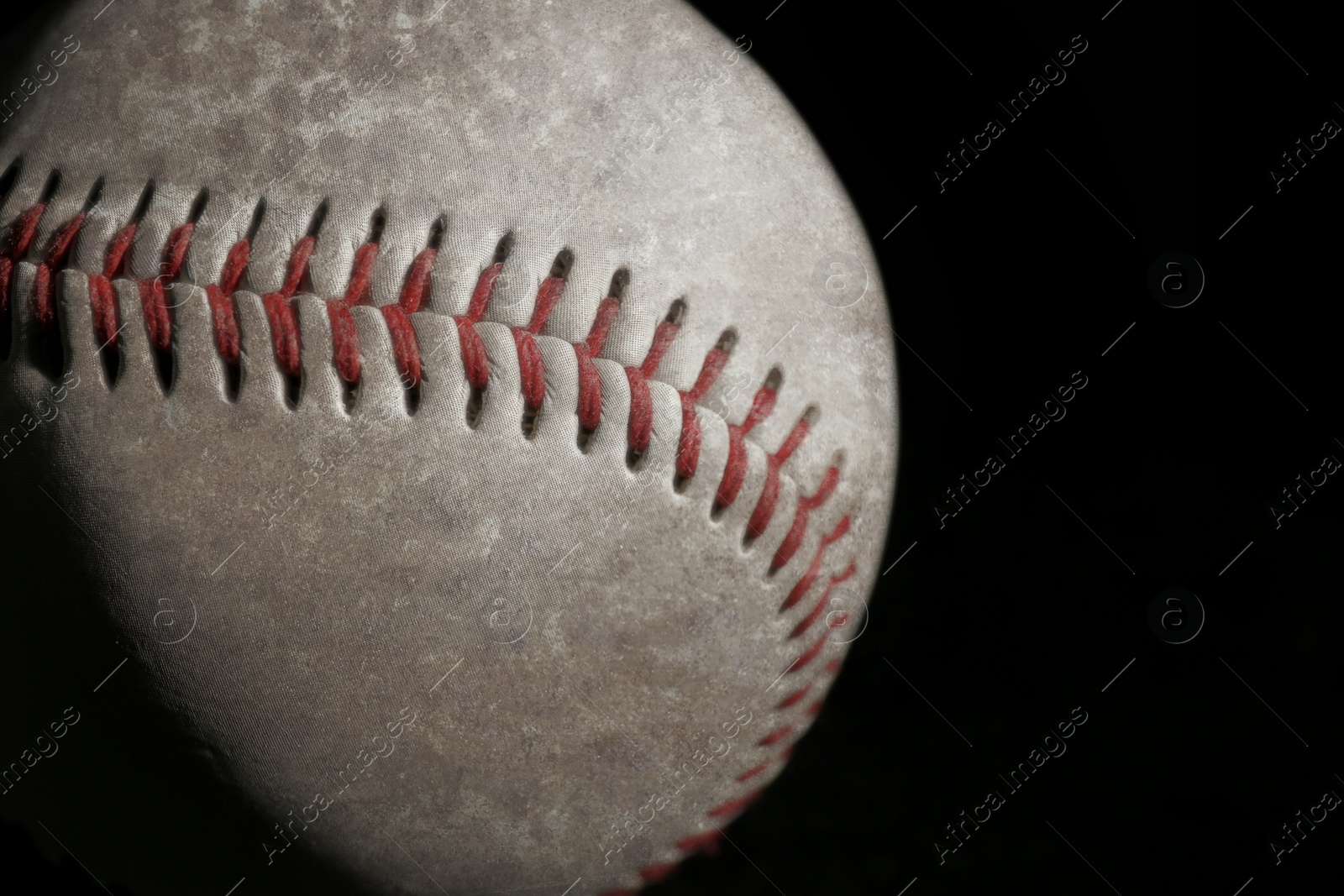 Image of Worn baseball ball on black background, closeup. Space for text