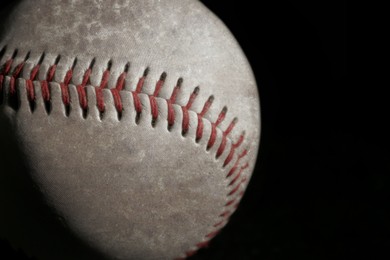 Image of Worn baseball ball on black background, closeup. Space for text