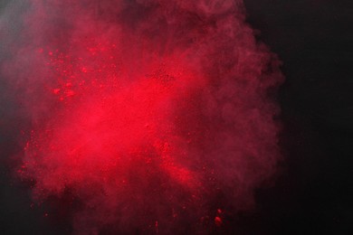 Photo of Red powder dye on dark background, top view. Holi festival