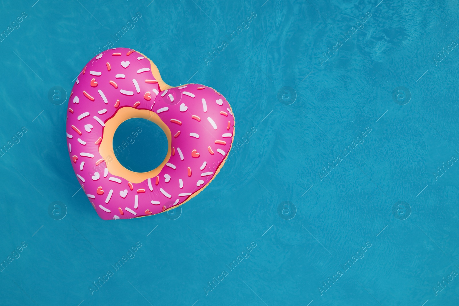 Image of Top view of inflatable ring floating in swimming pool, space for text. Summer vacation